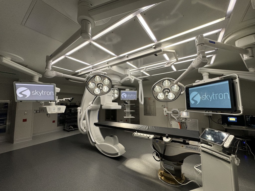 Hybrid operating room with imaging system, booms, and integrated surgical lighting